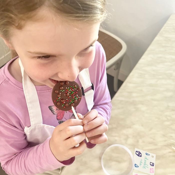 A child with a handmade chocolate lollipop