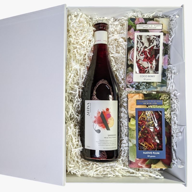 A gift hamper with non-alcoholic wine, a coco berry chocolate bar and a native plum chocolate bar in a white hamper box.