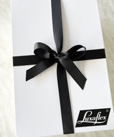 A white corporate gift hamper with a black ribbon and corporate logo