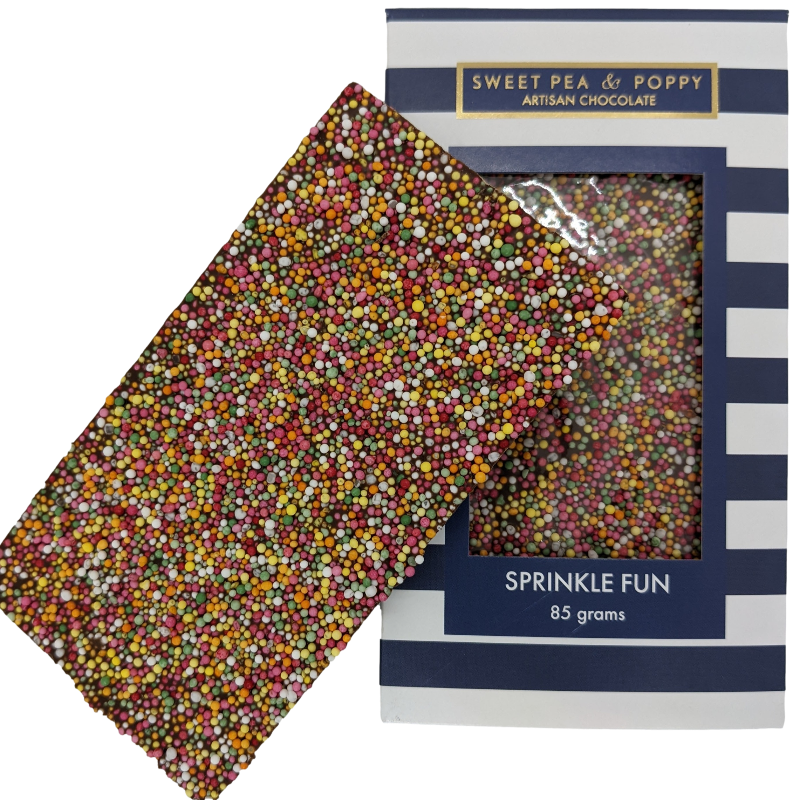 A milk chocolate and sprinkle chocolate bar sitting on top of a packaged Sprinkle Fun chocolate bar