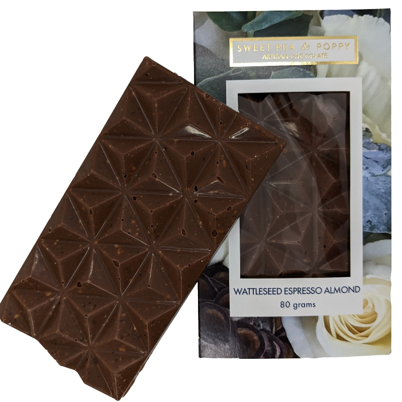 A milk chocolate Wattleseed Espresso Almond  chocolate bar sitting on top of a packaged Wattleseed Espresso Almond chocolate ba