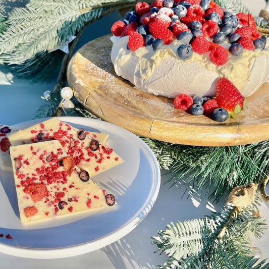 A festive Australian pavlova with a white chocolate pavlova bar on a platter