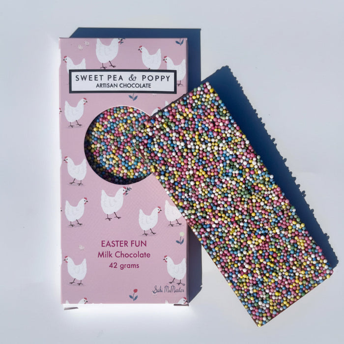 Sweet Pea & Poppy Easter Fun Chocolate bar with sprinkles next to a pink packaging box featuring chicken illustrations on a light gray background.