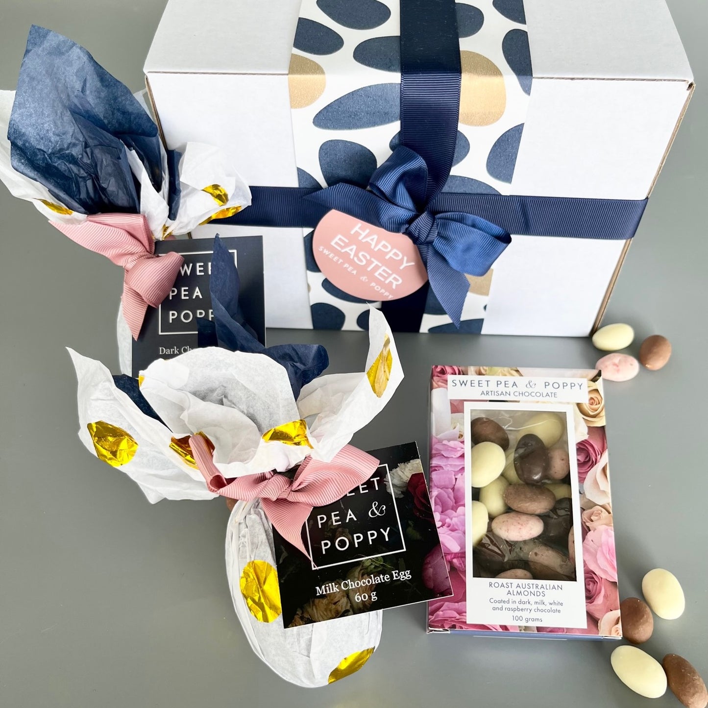 A gift box with wrapped easter eggs and chocolate coated almonds