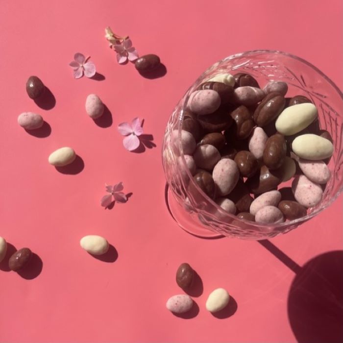 A glass dish with chocolate coated Australian almonds