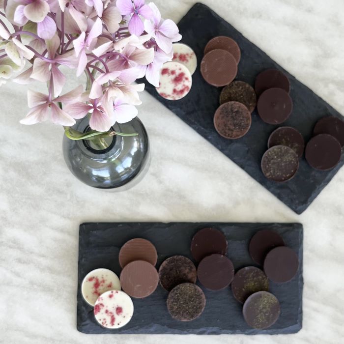 A table set with two plates of chocolate tasting discs