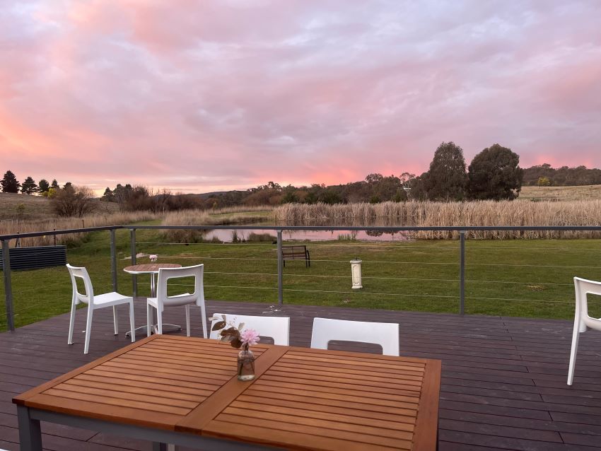 Tables and chairs on the deck overlooking country views at the Sweet Pea & Poppy cafe