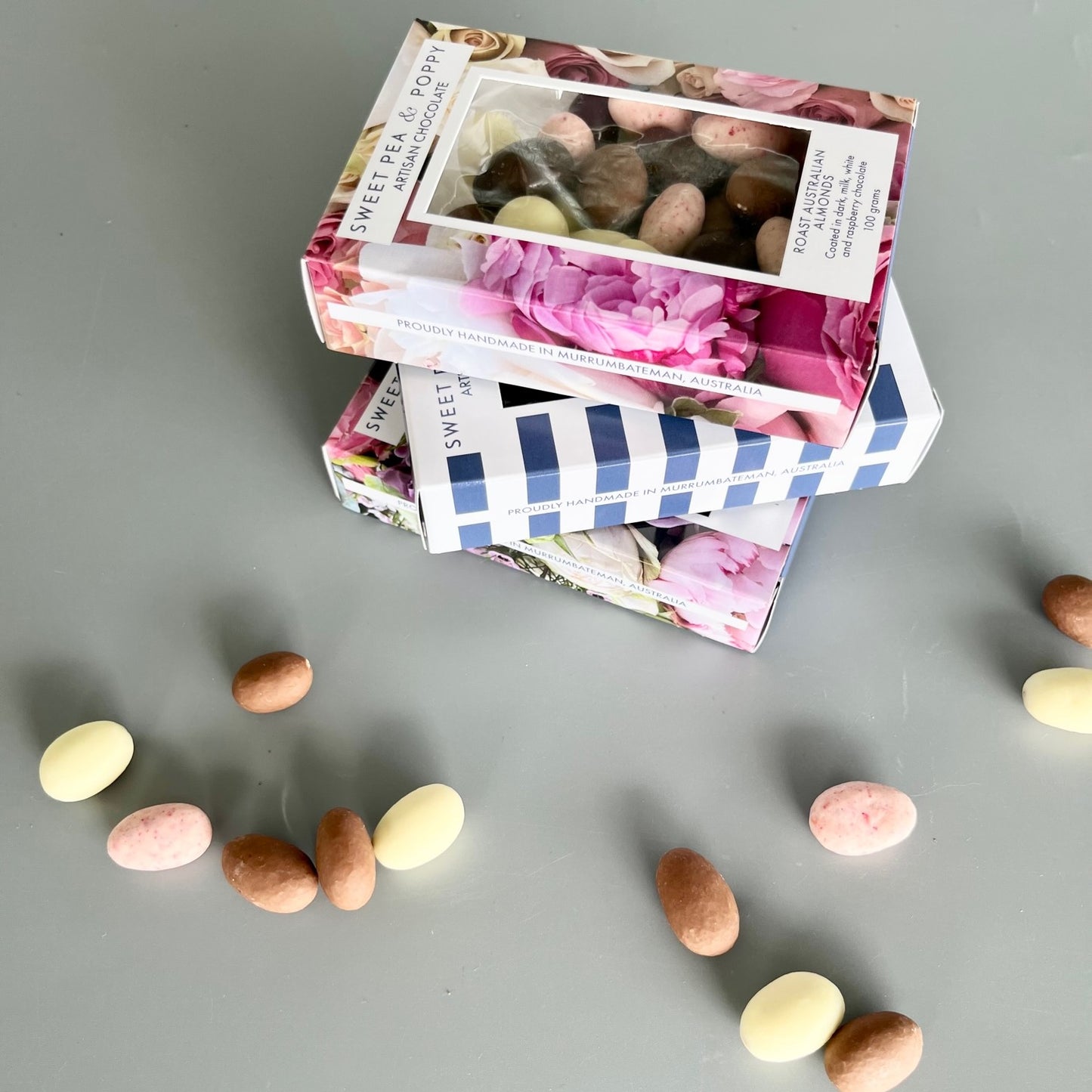 Three boxes of chocolate coated nuts: dark chocolate almonds, milk chocolate Wattleseed hazelnuts, chocolate coated almond medley