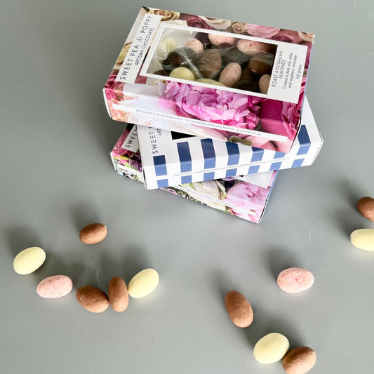 Three boxes of chocolate coated nuts: dark chocolate almonds, milk chocolate Wattleseed hazelnuts, chocolate coated almond medley