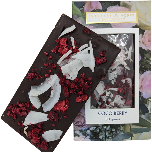 A dark chocolate, raspberry and coconut Coco Berry chocolate bar sitting on top of a packaged Coco Berry chocolate bar