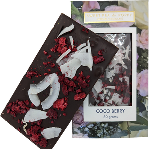 A dark chocolate, raspberry and coconut Coco Berry chocolate bar sitting on top of a packaged Coco Berry chocolate bar