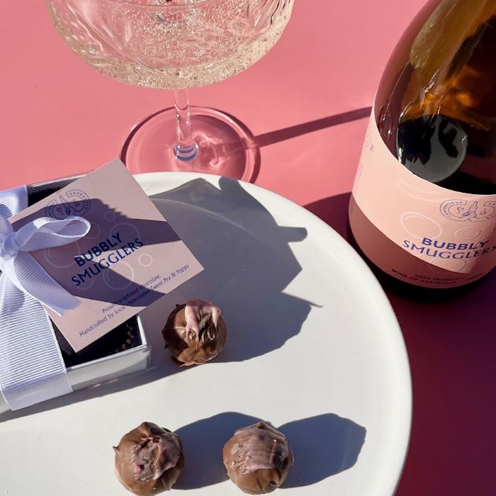 A gift box of handmade prosecco chocolates with a bottle of Contentious Character Bubbly Smugglers prosecco