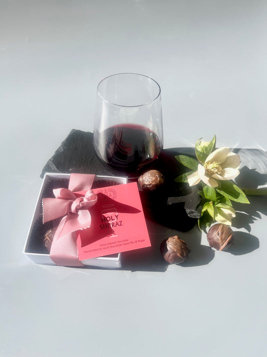 A gift box of shiraz chocolate truffles with a glass of shiraz