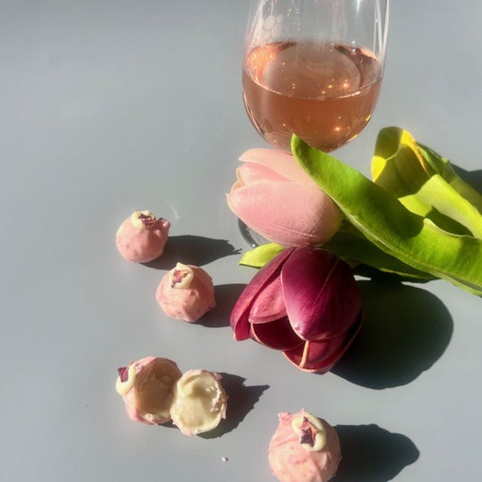 pink and white chocolate truffles with wine and tulips