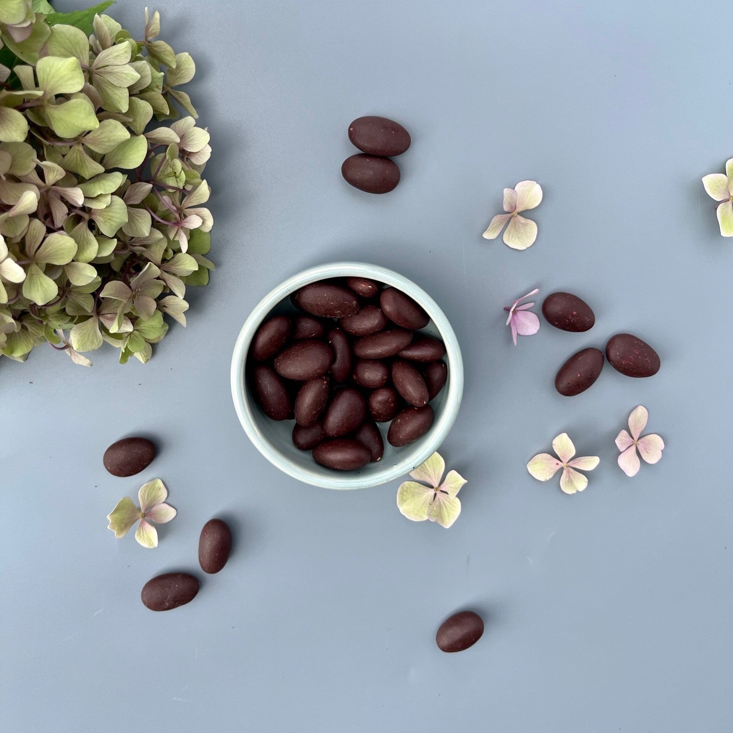 A bowl and a selection of chocolate coated Australian almonds