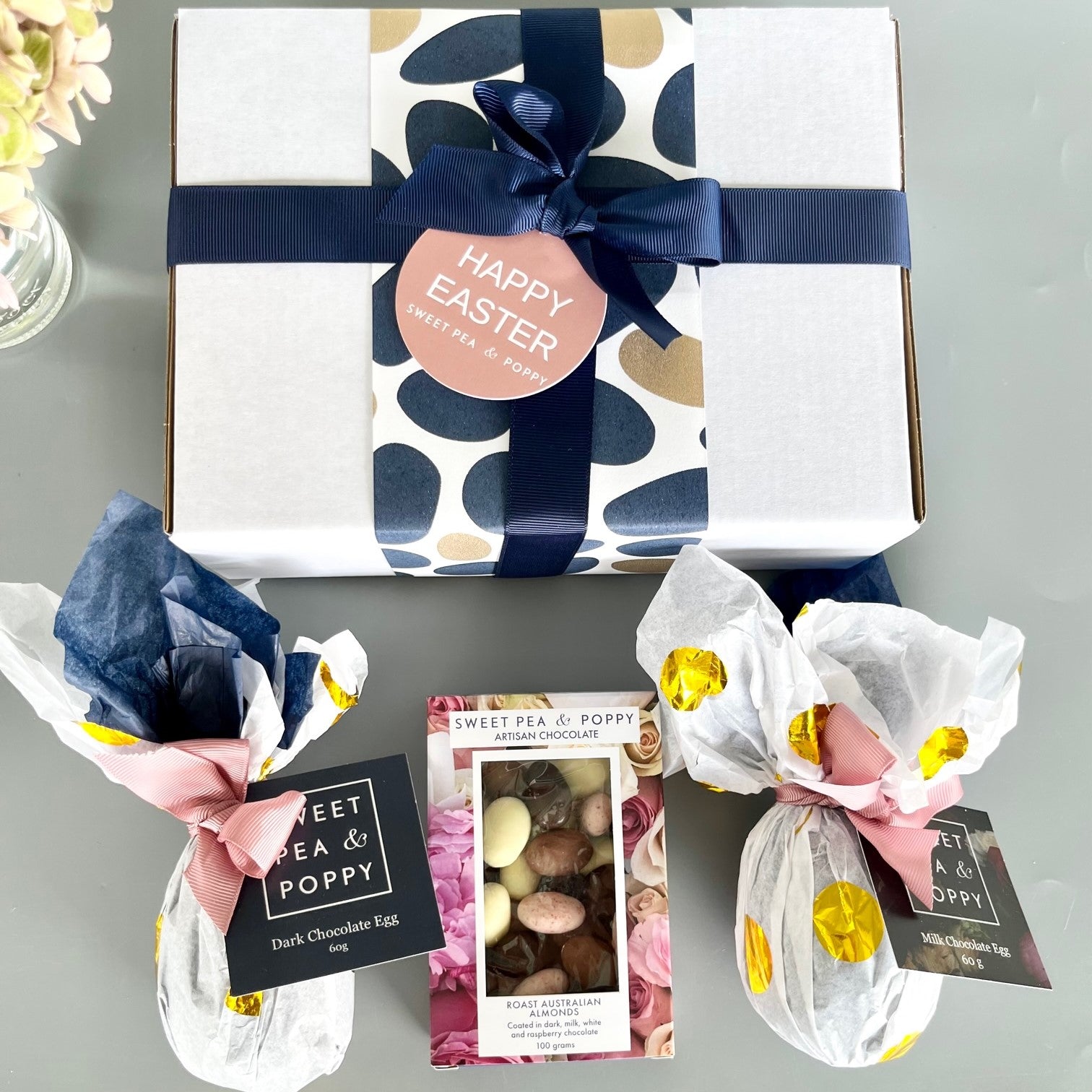 A gift box with wrapped easter eggs and chocolate coated almonds