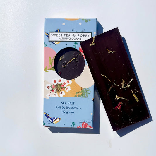 Dark chocolate bar with sea salt and decorative packaging on a white background