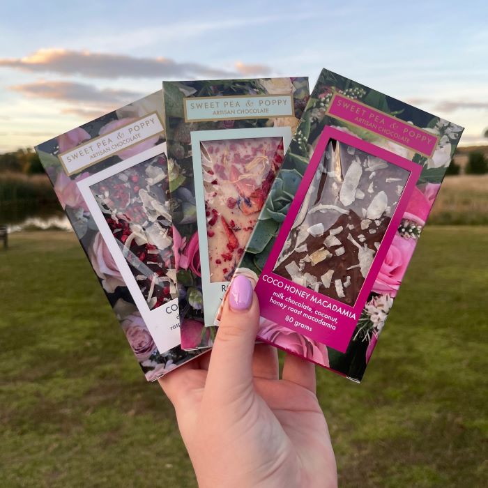 A bundle of three handmade chocolate bars with a country view background