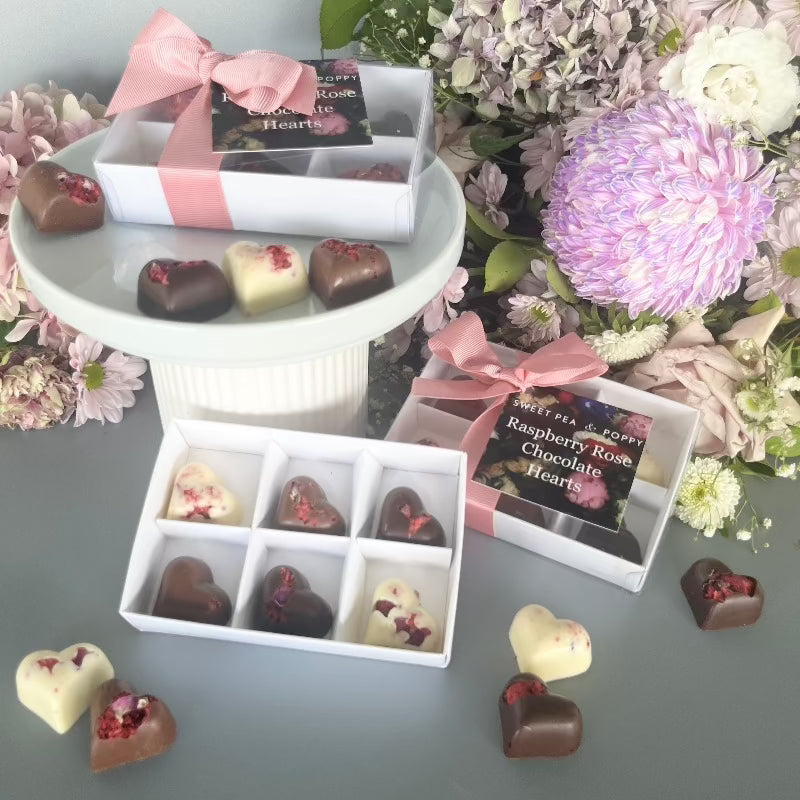 Three gift boxes of heart shaped chocolates with a floral background