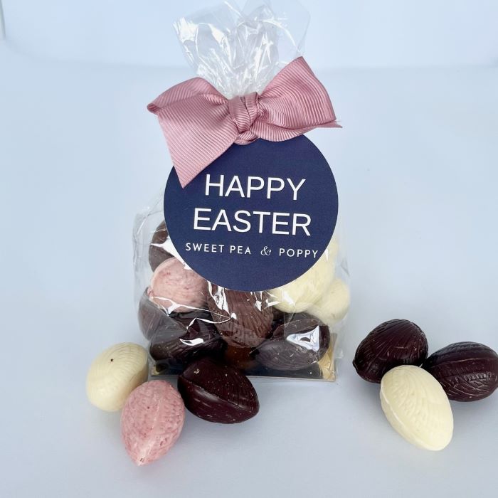 A compostable cello bag with solid Easter eggs, finished with a ribbon bow