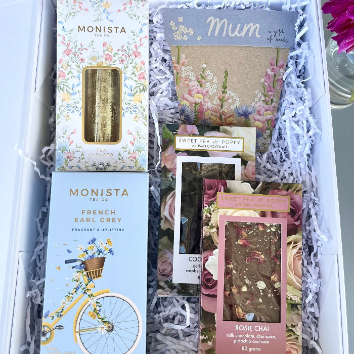 Gift set with chocolate, Monista tea packages and a gift of seeds card inside a gift hamper box