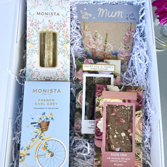 Gift set with chocolate, Monista tea packages and a gift of seeds card inside a gift hamper box