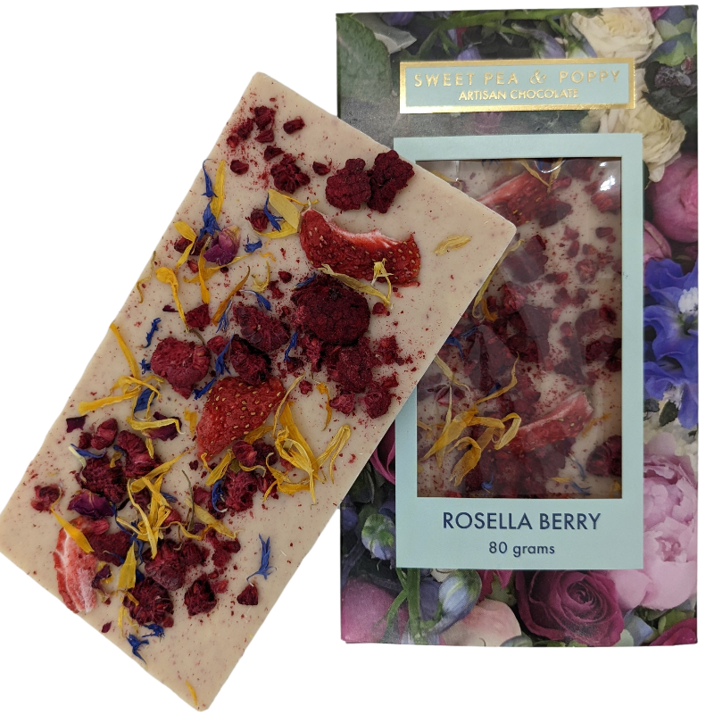 A picture of a white chocolate Rosella Berry bar on top on a packaged white chocolate rosella berry chocolate bar