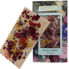 A picture of a white chocolate Rosella Berry bar on top on a packaged white chocolate rosella berry chocolate bar