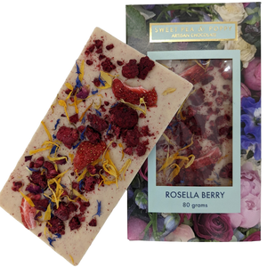 A picture of a white chocolate Rosella Berry bar on top on a packaged white chocolate rosella berry chocolate bar