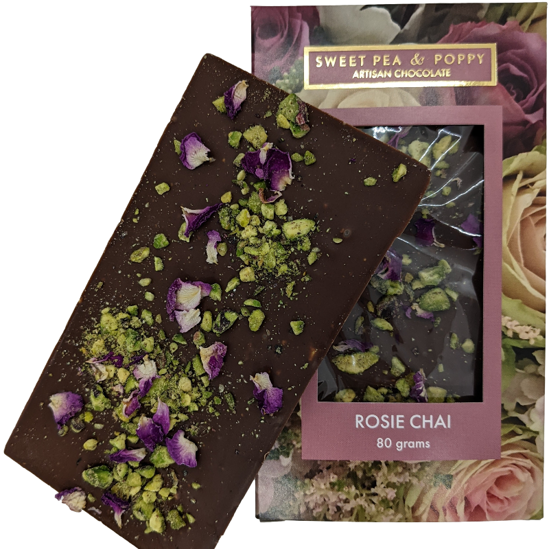 A picture of a milk chocolate Rosie Chai bar on top on a packaged milk chocolate Rosie Chai chocolate bar