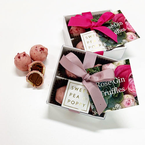 Two gift boxes of gin chocolate truffles with three individual chocolate truffles shown in foreground