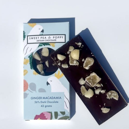 Ginger Macadamia dark chocolate bar with packaging on a light blue background