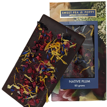 An unpackaged Native Plum dark chocolate bar with native plum and raspberry, sitting on top of a Sweet Pea & Poppy Native Plum packaged chocolate bar