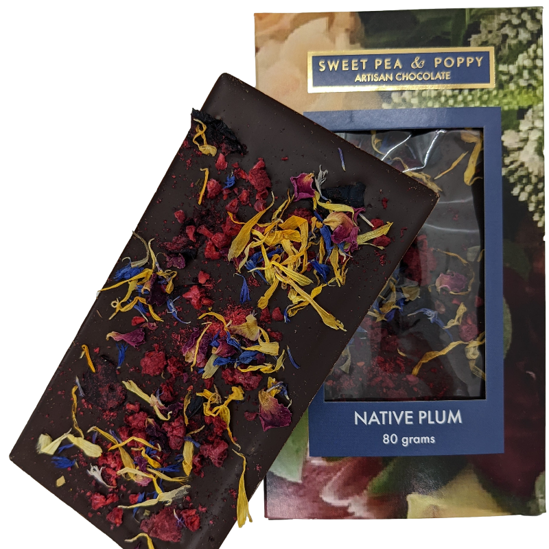 An unpackaged Native Plum dark chocolate bar with native plum and raspberry, sitting on top of a Sweet Pea & Poppy Native Plum packaged chocolate bar