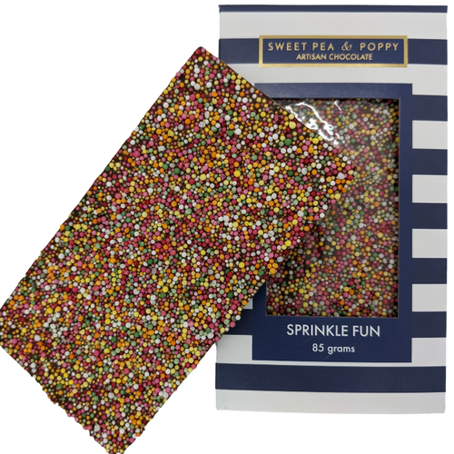 A milk chocolate and sprinkle chocolate bar sitting on top of a packaged Sprinkle Fun chocolate bar