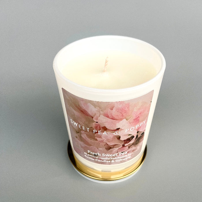 Candle in a white jar with floral design on a grey background