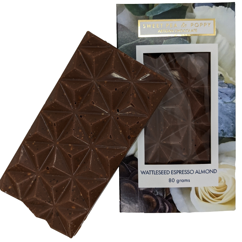 A picture of a milk chocolate Espresso Almond Wattleseed bar on top on a packaged milk chocolate, espresso almond wattleseed chocolate bar